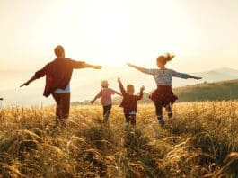 Happy Family: Mother, Father, Children Son And Daughter On Sunset