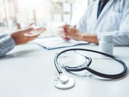 Doctors And Patients Consulting And Diagnostic Examining Sit And Talk. At The Table Near The Window In The Hospital Medicine Concept