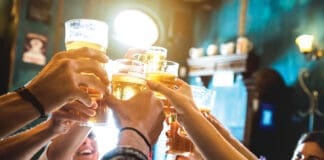 Group Of Happy Friends Drinking And Toasting Beer At Brewery Bar Restaurant Friendship Concept With Young People Having Fun Together At Cool Vintage Pub Focus On Middle Pint Glass High Iso Image