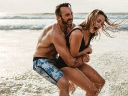 Playful Couple Having Fun On Their Summer Beach Vacation