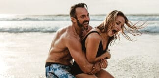 Playful Couple Having Fun On Their Summer Beach Vacation