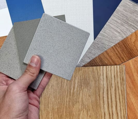 Interior Designer's Hand Holding Quartz Stone Samples Matching Color With Wood Vinyl Flooring Tiles, Engineering Wood Tiles, Stone Tiles, Solid Color Laminateds, Artificial Stone Tiles. Close Up View.