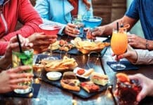 Group Of Friends Enjoying Appetizer Drinking And Eating In A Bar Close Up Of Hands Of Young People Holding Colorful Cocktails In The Happy Hour Time Social Gathering Party Time Concept
