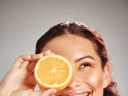 Orange, Beauty And Woman Face In Studio With A Smile For Natural Skin Glow, Cosmetic And Dermatology. Facial Results, Health And Wellness Of Aesthetic Model Person Happy With Vitamin C Fruit Idea