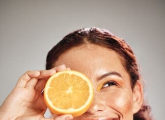 Orange, Beauty And Woman Face In Studio With A Smile For Natural Skin Glow, Cosmetic And Dermatology. Facial Results, Health And Wellness Of Aesthetic Model Person Happy With Vitamin C Fruit Idea