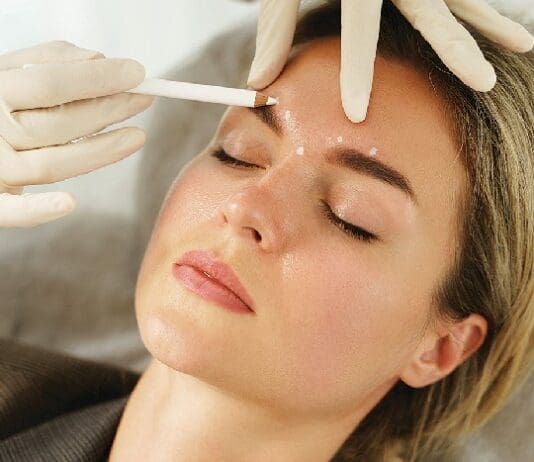 Doctor Making Marks On Client's Face Before Filler Injection