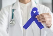 Why Everyone Needs to Talk about Colorectal Cancer Screening at 45 Dark Blue Ribbon For Colon Colorectal Cancer Awareness On Medical Doctor's Hand Support